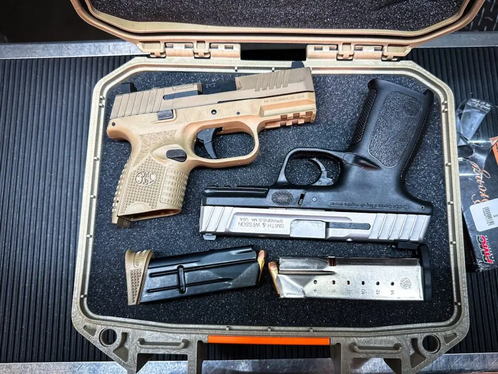Close-up of pistols and magazines neatly arranged in a protective gun case.