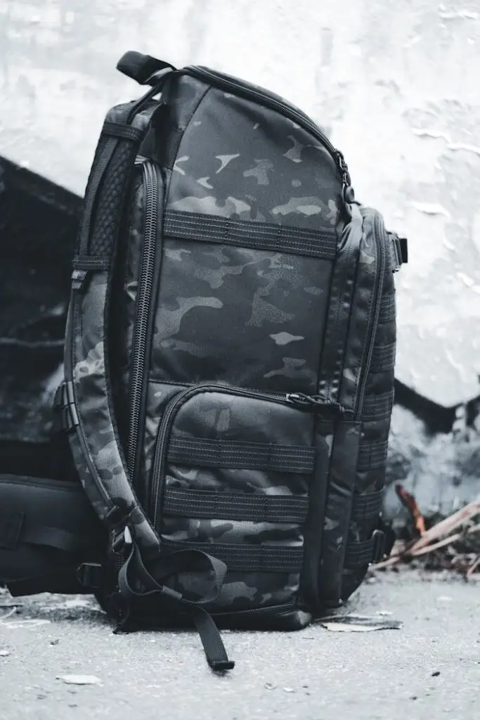 Camouflage backpack resting against an urban wall, perfect for travel and outdoor adventures.