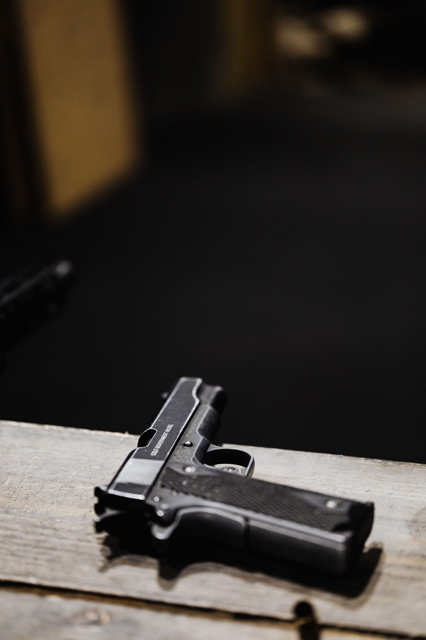 Close-up of a pistol on a wooden surface, illustrating gear and equipment selection