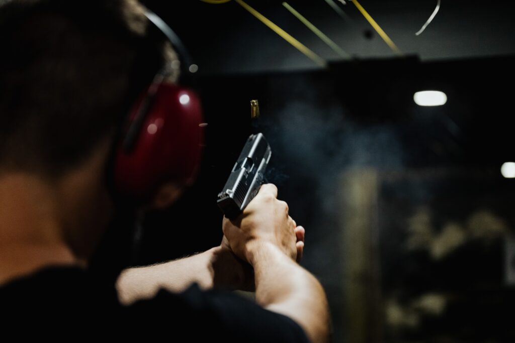 Shooter at an indoor range completing a live-fire qualification, part of Maryland's Wear and Carry Permit training requirement