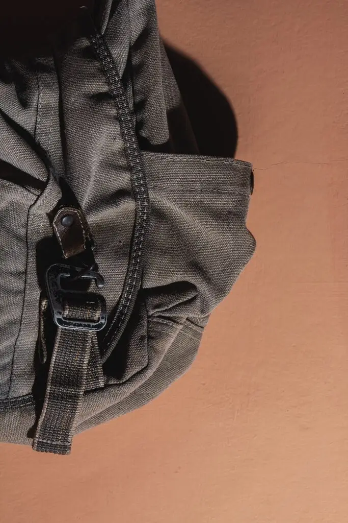 Close-up detail of a gray daypack showing fabric and hardware quality