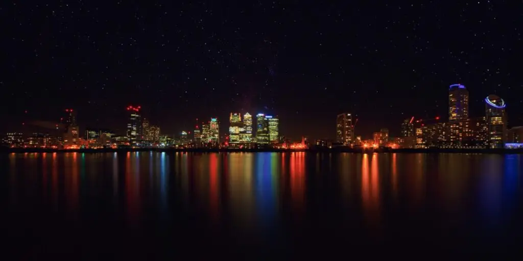 City skyline at night reflected in the water, representing concealed carry laws that change from city to city