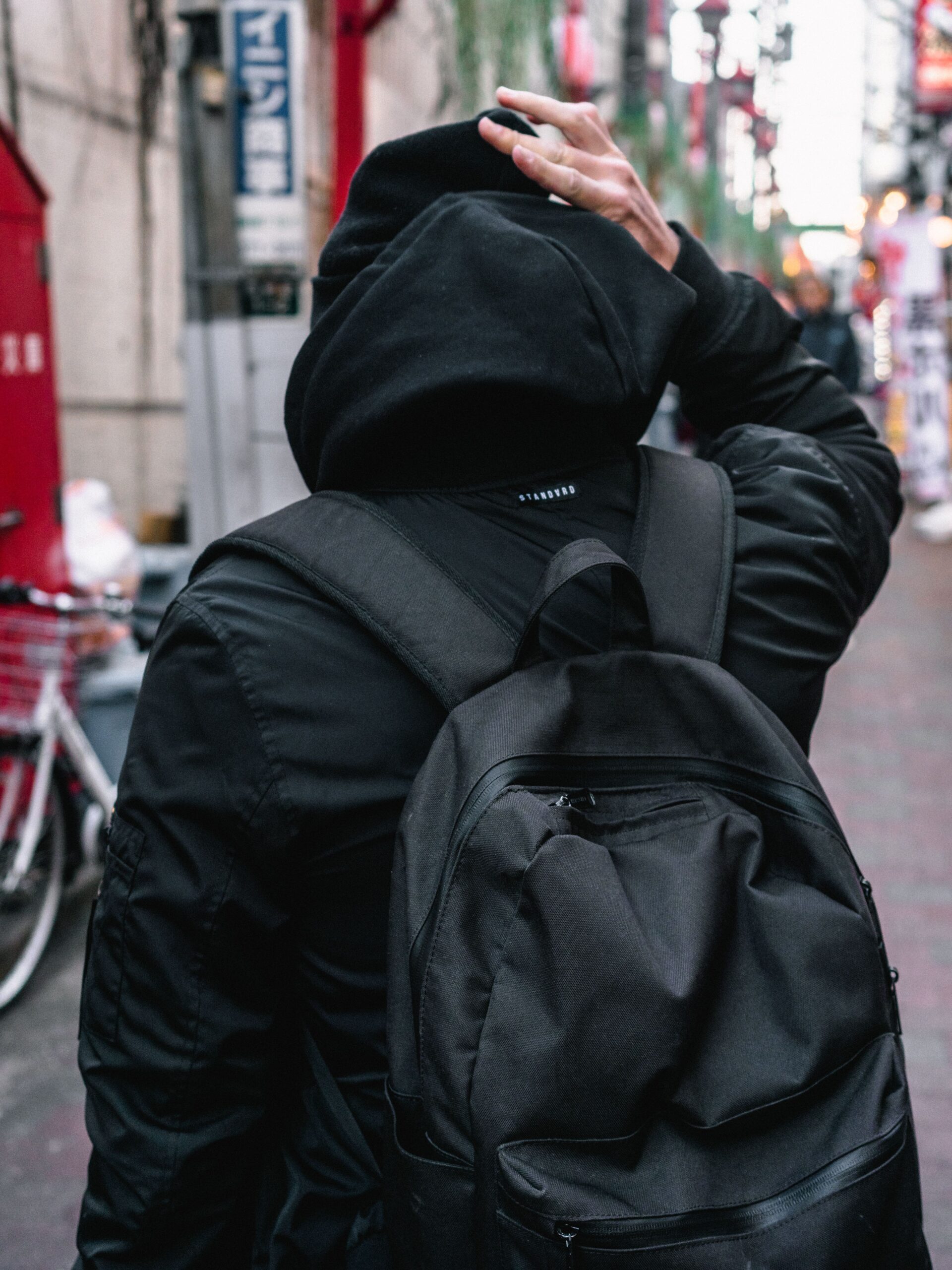 Person walking an urban street wearing a backpack