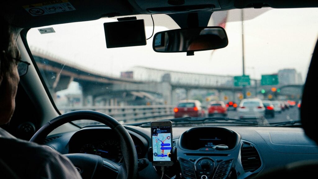 Driver in morning city traffic with navigation on the dashboard