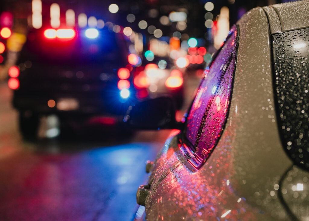 Police car with flashing lights stopped on a city street