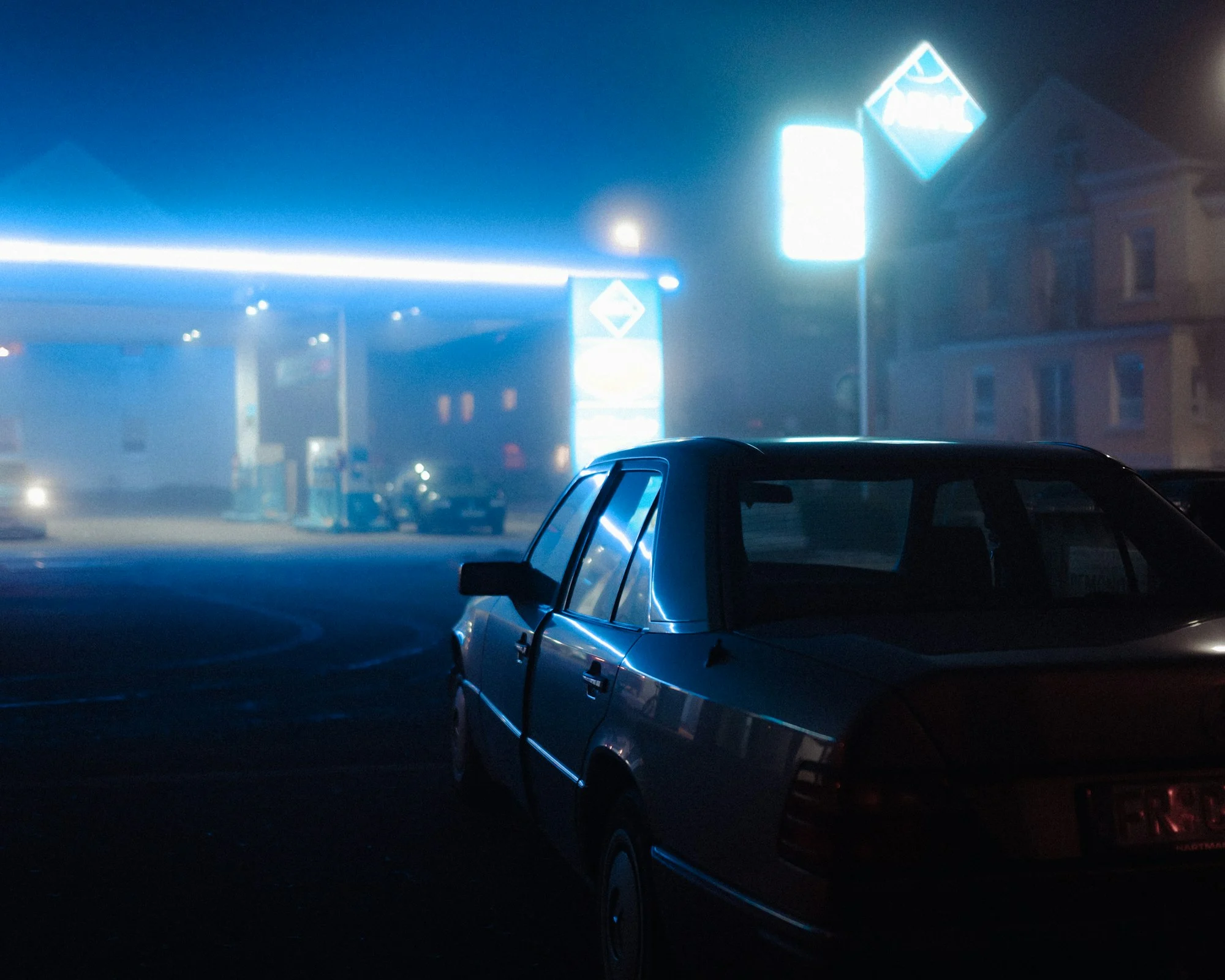 Black sedan on a city street at night